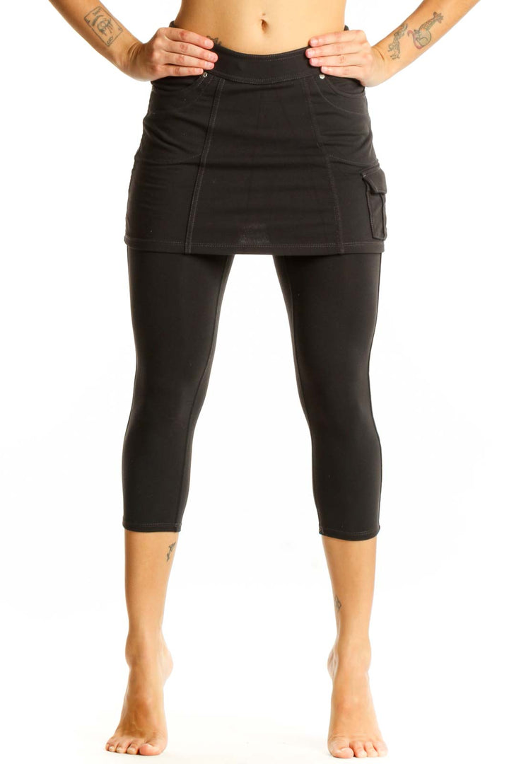 Front view of Athleta black cotton skirted capri leggings on model