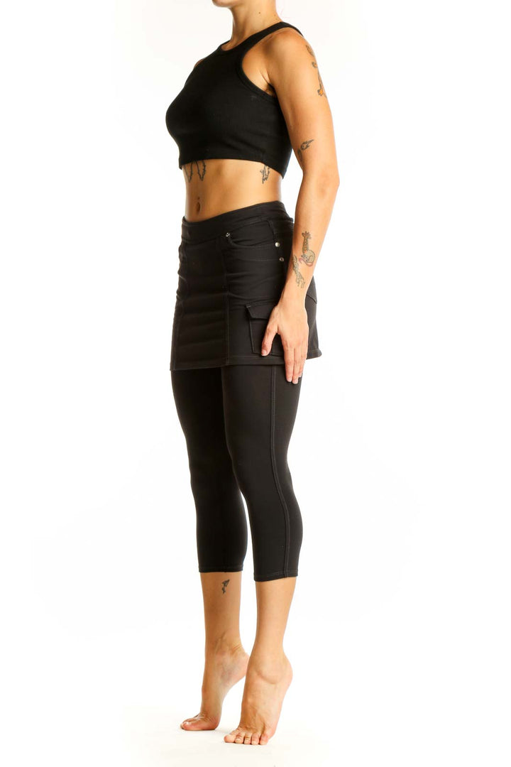Front view of Athleta black cotton skirted capri leggings on model