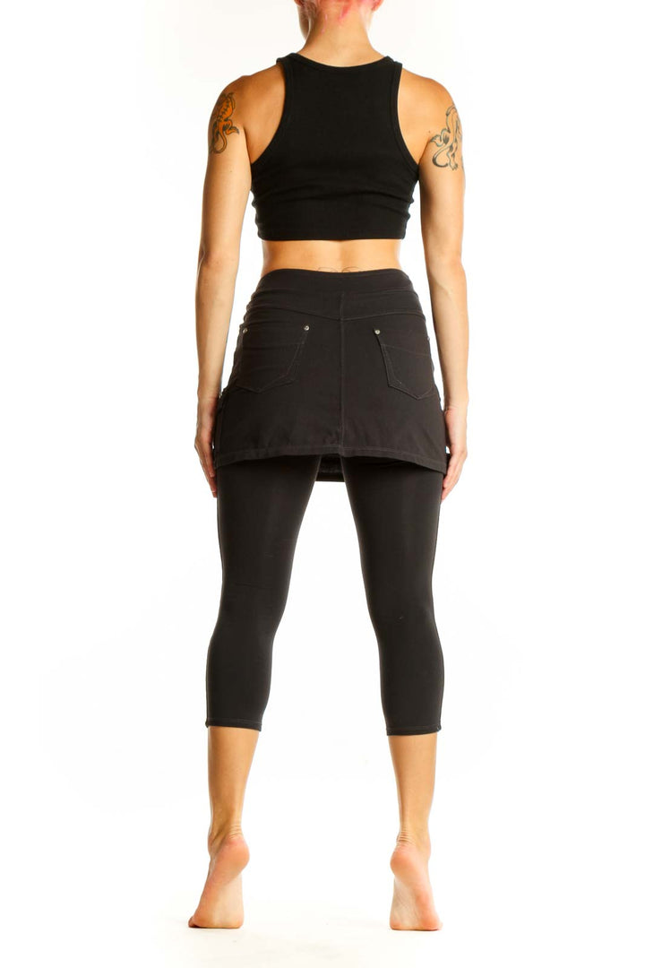 Side view of Athleta black cotton skirted capri leggings on model
