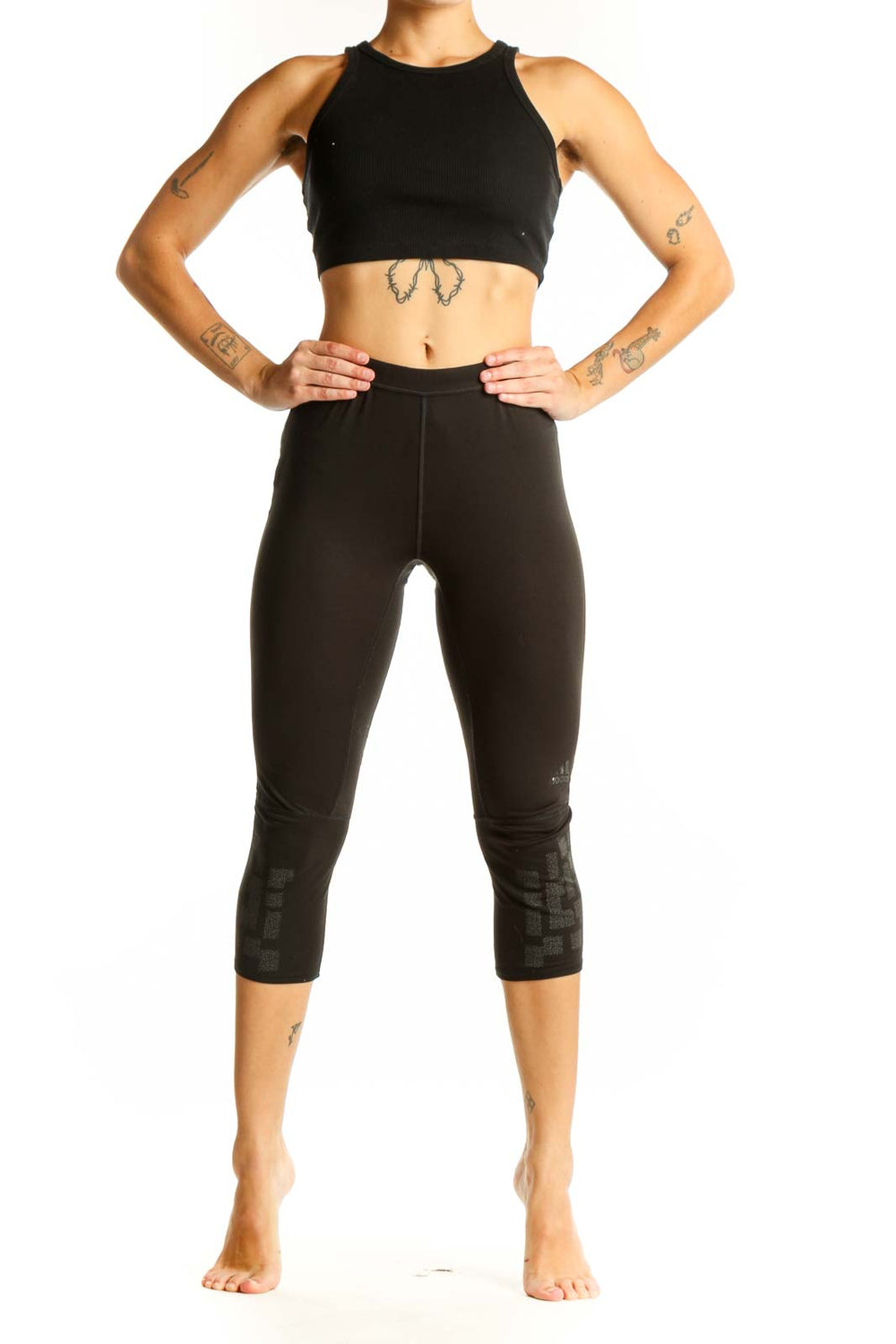 Front view of black Adidas capri leggings with patterned lower leg detail