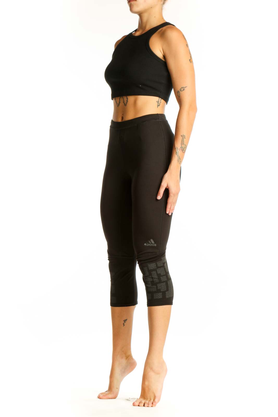 Front view of black Adidas capri leggings with patterned lower leg detail