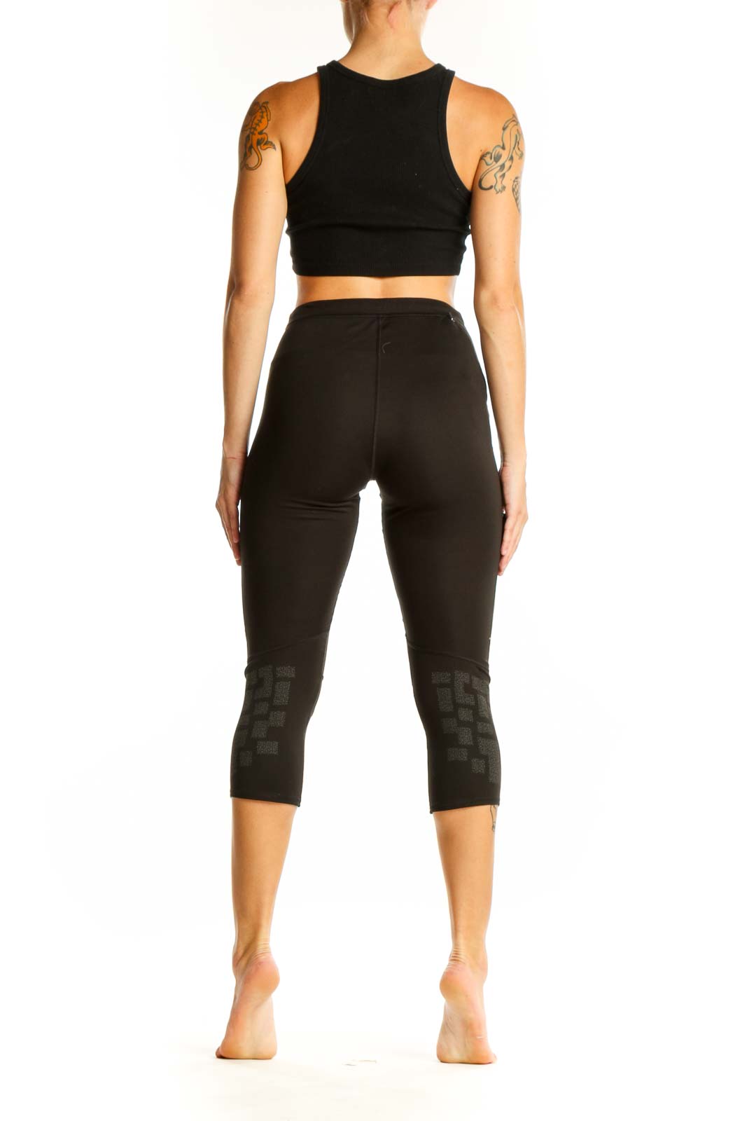 Side view of woman wearing black Adidas capri leggings and matching crop top