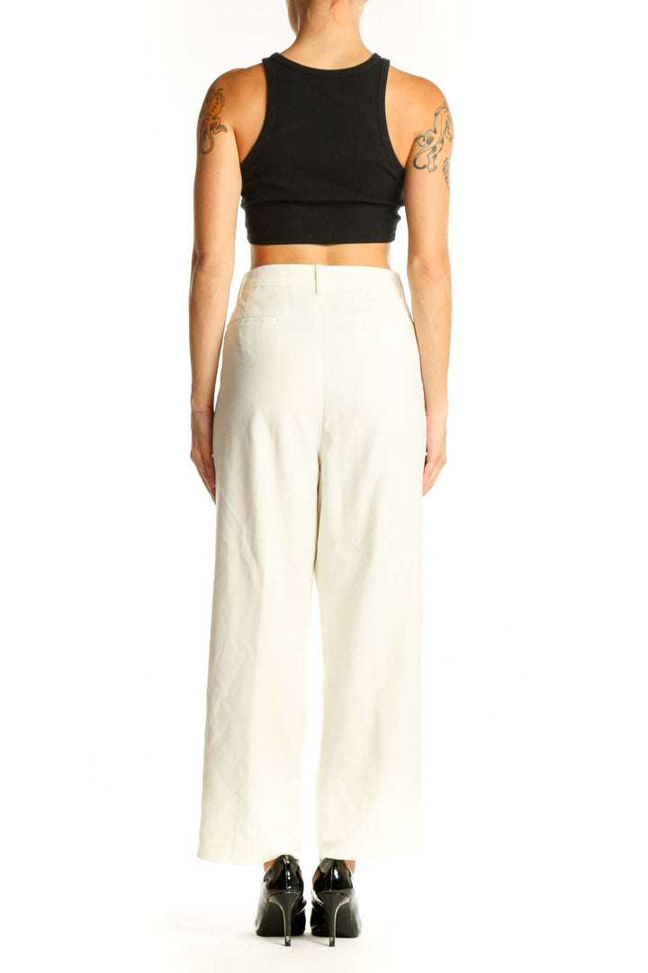 Side view of white wide-leg dress pants paired with black crop top