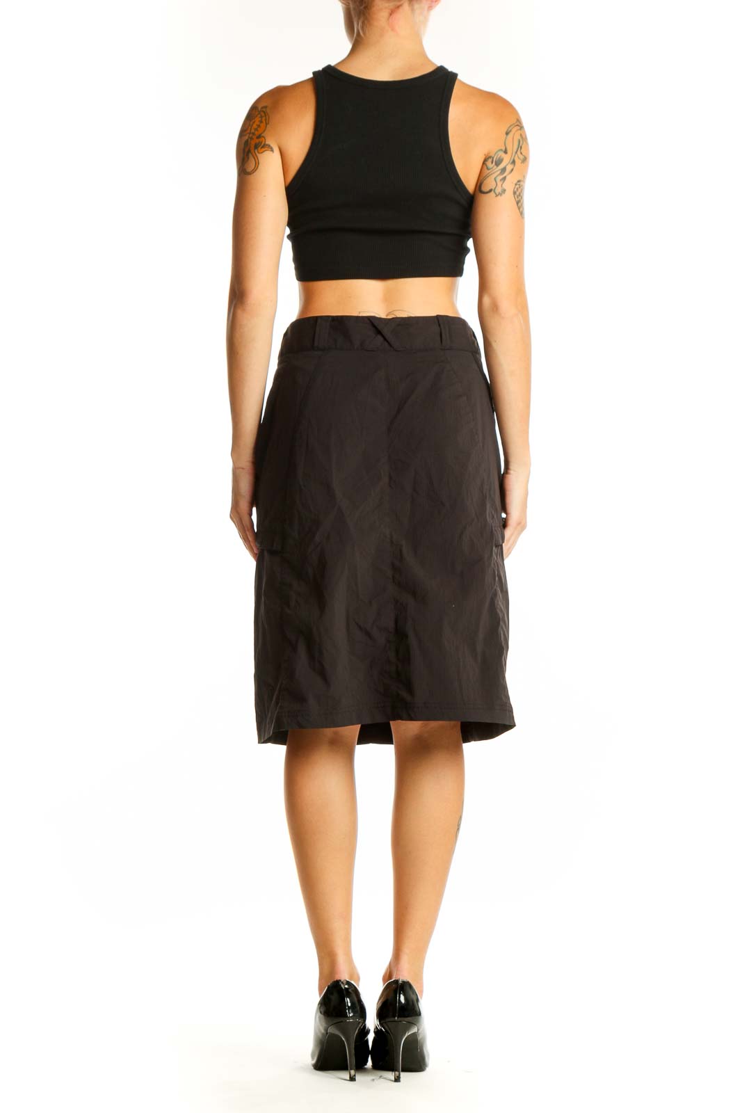 Side view of Exofficio black knee-length skirt on model with crop top