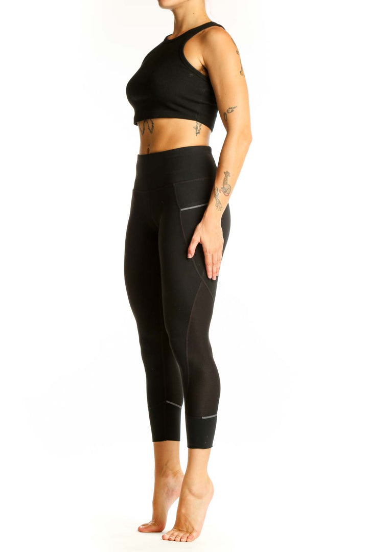 Front view of black Nike high-waisted cropped leggings with side pockets