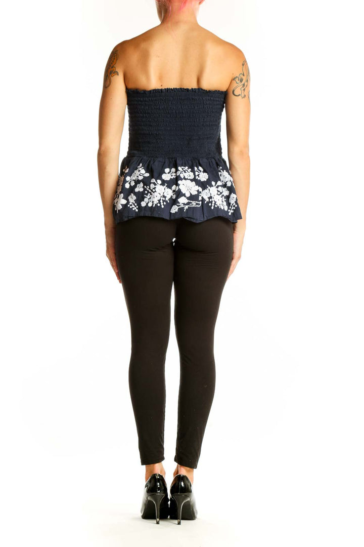 Side view of Point Sur navy strapless top showing floral peplum detail