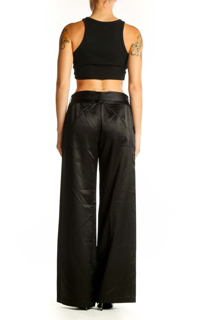 Side view of model wearing Armani Exchange black satin wide-leg dress pants