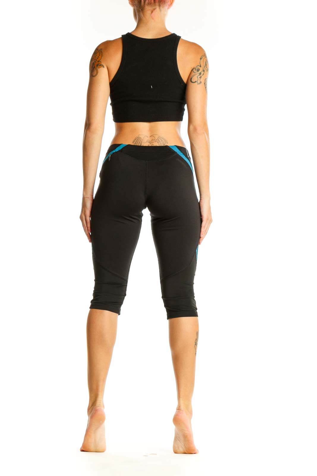 Side view of woman wearing black Adidas capri leggings with blue accents