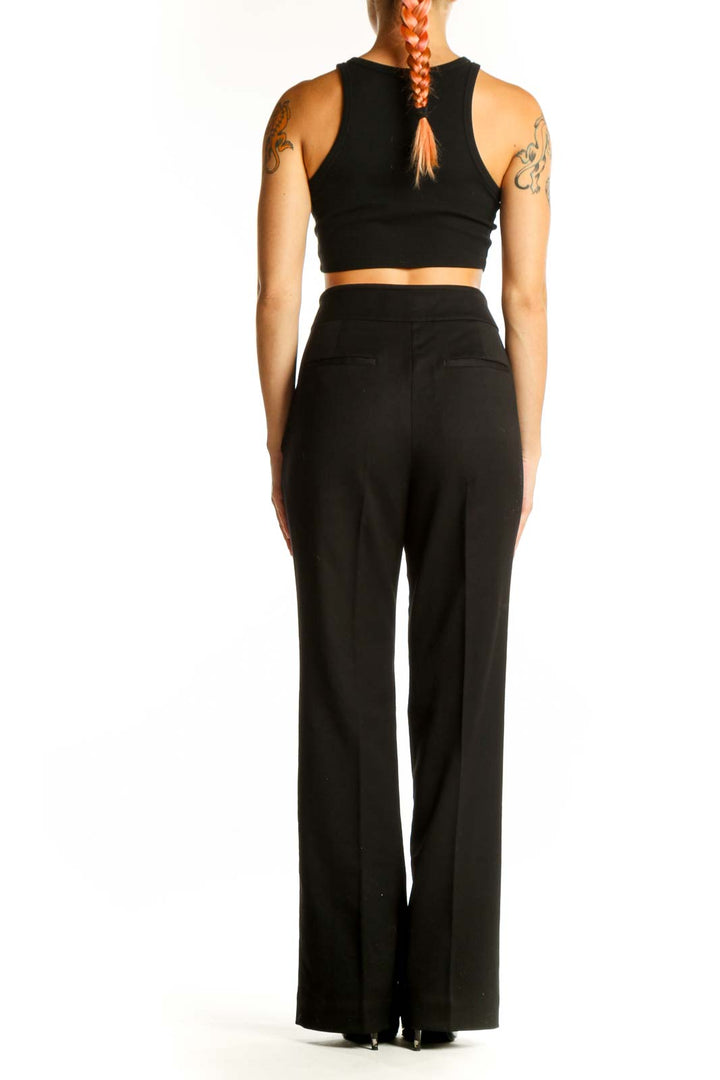 Side view of model wearing black wide-leg dress pants and crop top