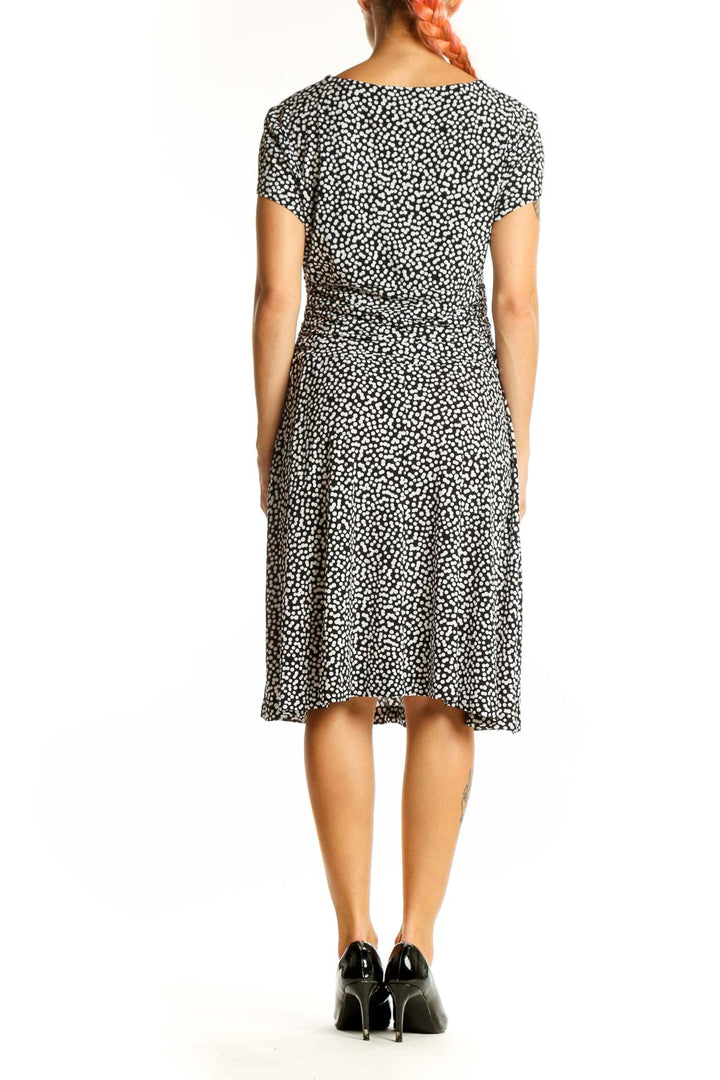 Side view of Connected Apparel black polka dot wrap dress showing silhouette