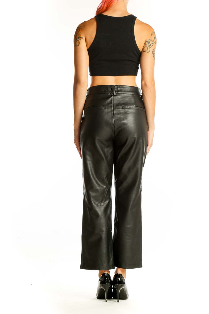 Side view of model wearing Maeve black faux leather wide-leg trousers