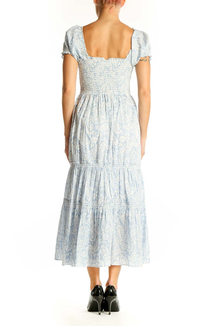 Side view of light blue floral midi dress showing tiered skirt and puff sleeves