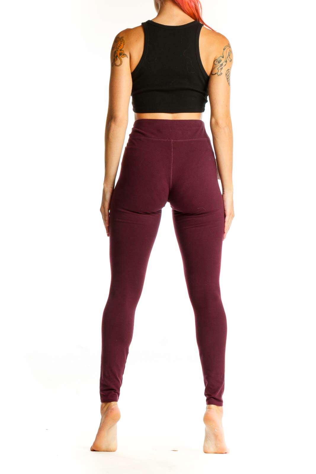 Side view of burgundy Pact leggings with black crop top on model