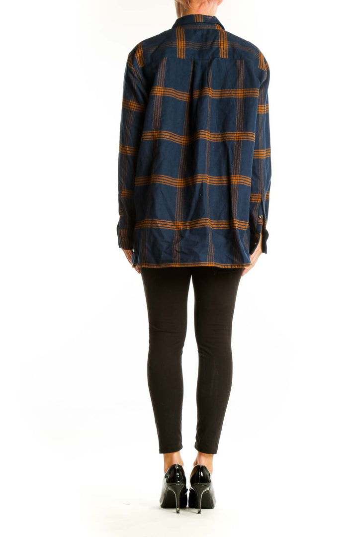 Side view of model wearing Madewell navy plaid cotton button-down shirt with black pants