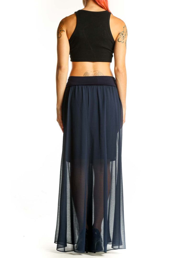 Side view of model wearing Vince Camuto navy sheer maxi skirt with black crop top