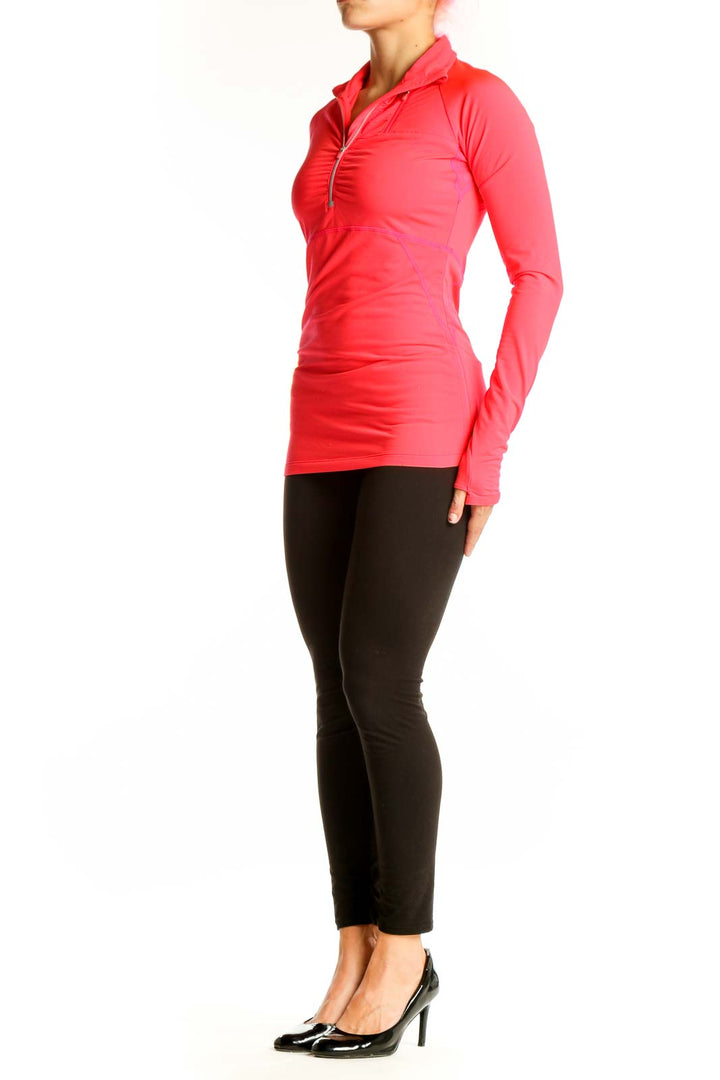 Front view of coral Athleta half-zip long sleeve athletic top
