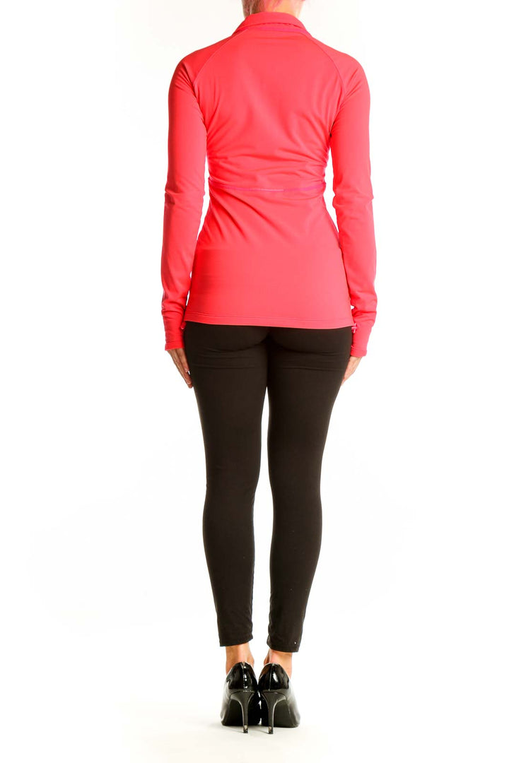 Side view of woman wearing coral Athleta half-zip long sleeve athletic top