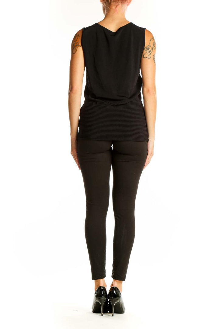 Side view of model wearing black BCBG MaxAzria tank top with dark pants