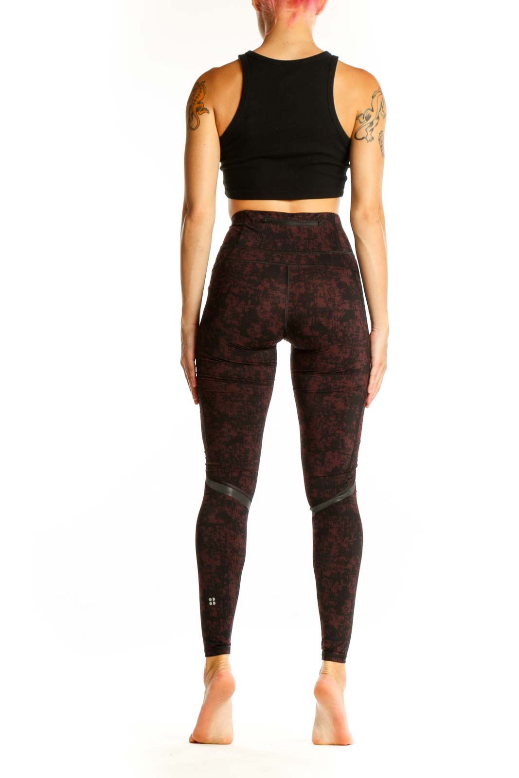Side view of woman wearing Sweaty Betty burgundy textured high-waist workout leggings with black crop top