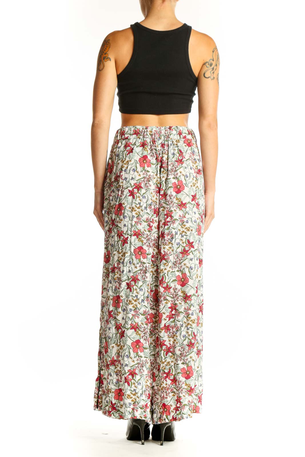 Side view of model wearing Jessica Simpson floral palazzo pants with black crop top