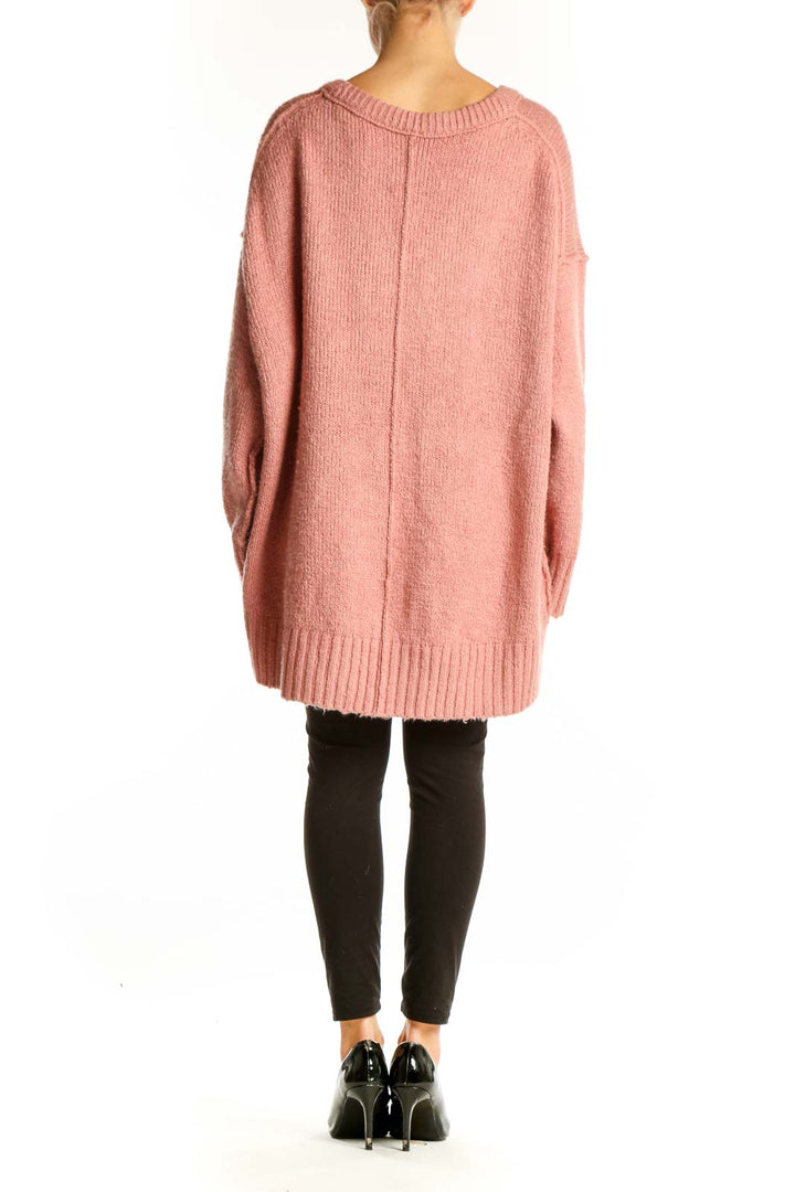 Side view of pink oversized V-neck knit sweater from Free People on model