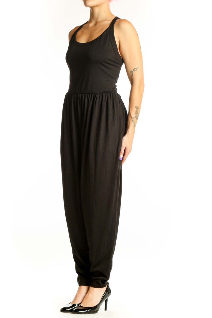 Black Halara jumpsuit with halter neckline and tapered legs, front view on model