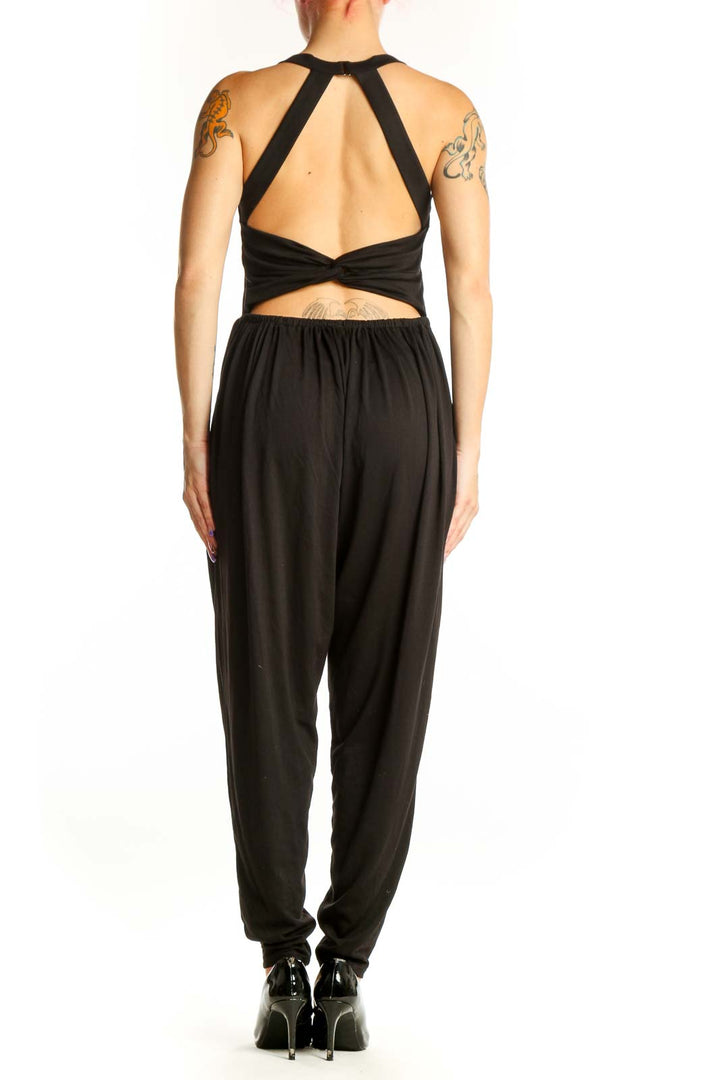 Black Halara jumpsuit with halter neckline and tapered legs, back view on model
