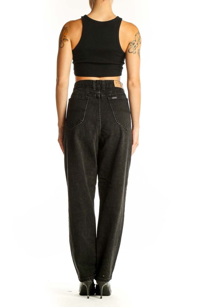 Side view of model wearing black high-waisted Riders Denim jeans with black crop top