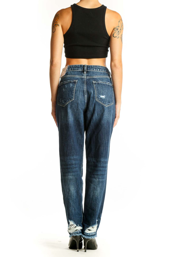 Side view of woman wearing Kancan dark blue distressed boyfriend jeans with raw hem