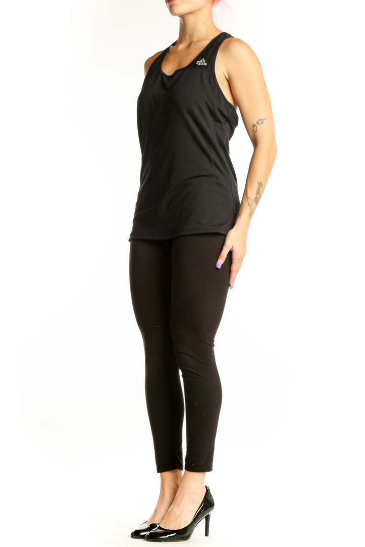 Black Adidas racerback athletic tank top with logo, front view on model