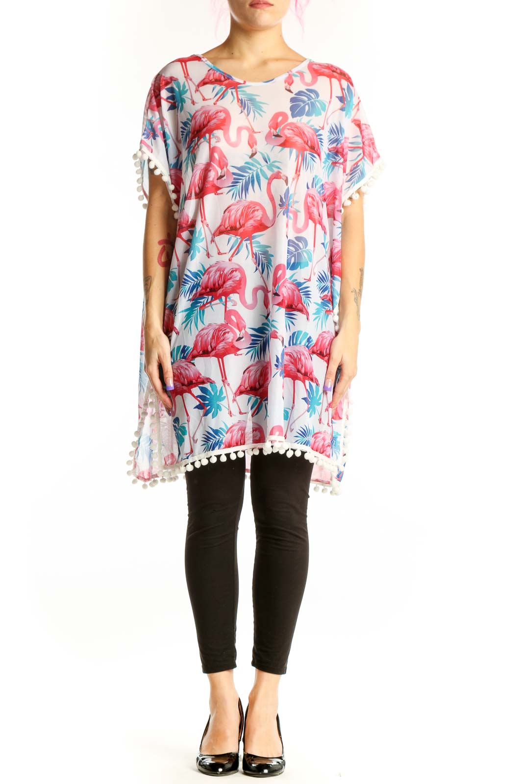 Cream tunic top with coral pink and teal flamingo tropical print, white pom-pom trim on sleeves, front view
