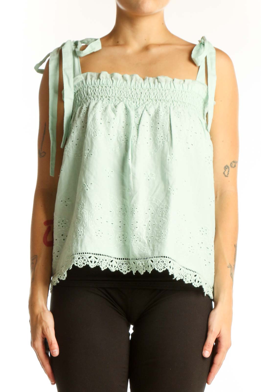 Front view of mint green eyelet lace sleeveless top with tie straps