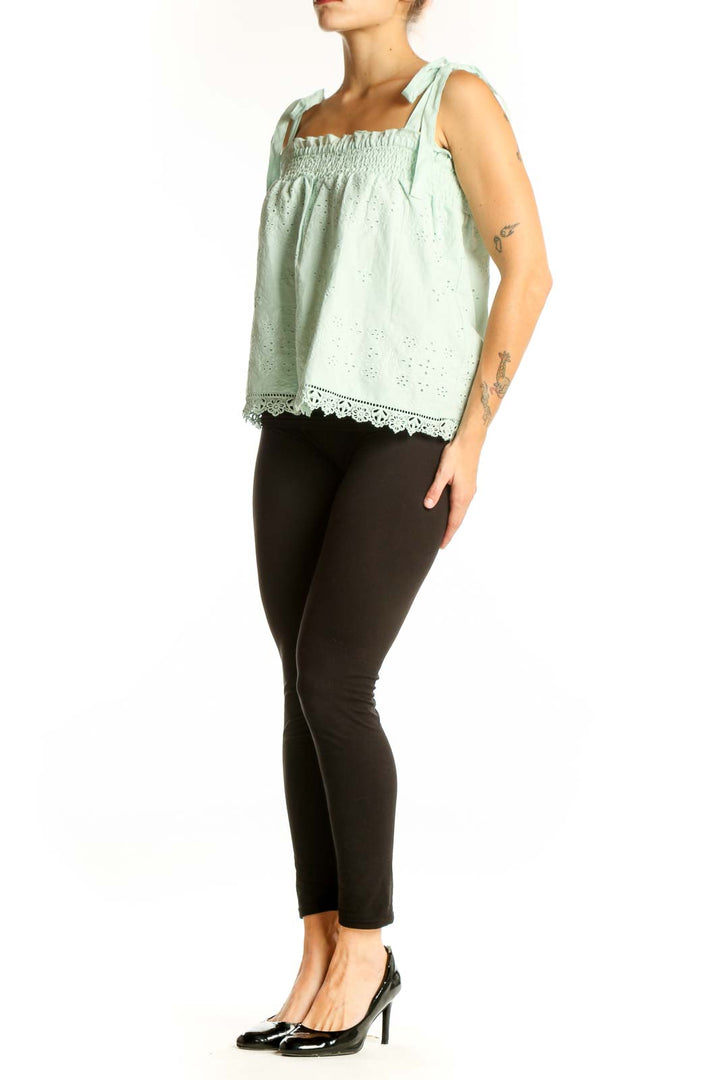 Front view of mint green eyelet lace sleeveless top with tie straps