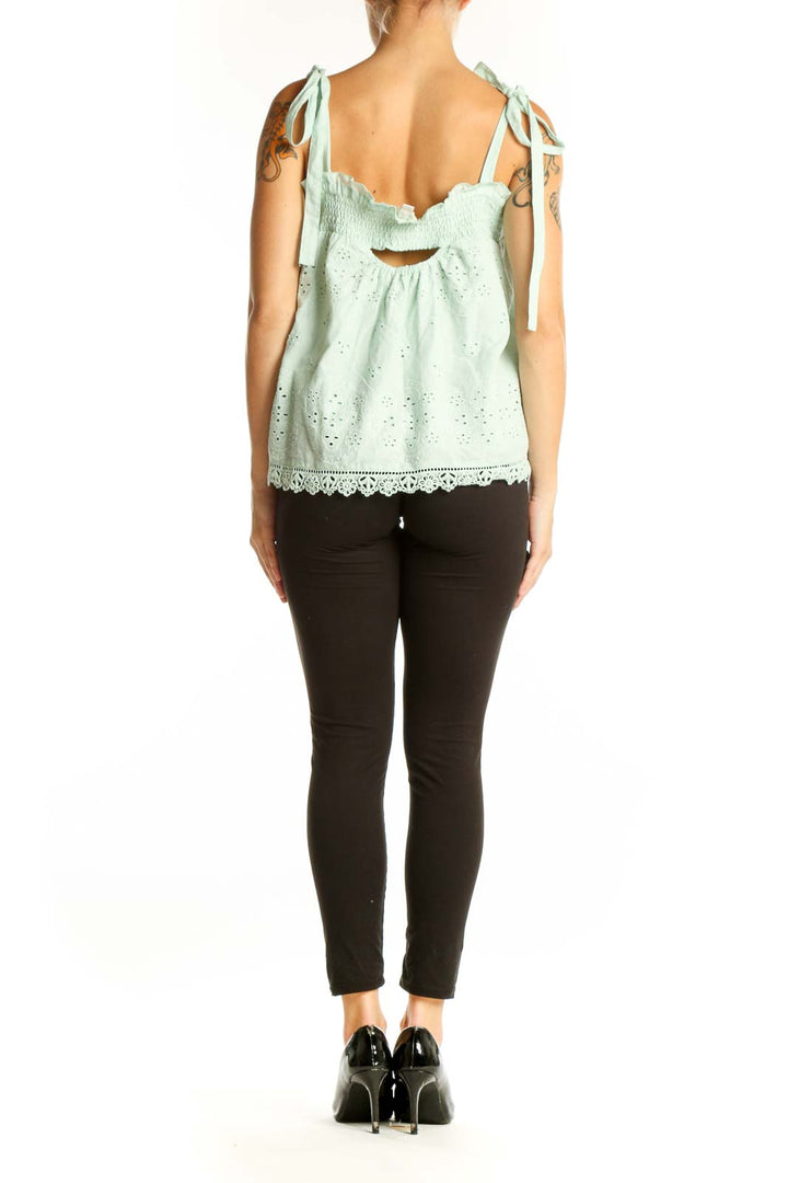 Side view of mint green eyelet lace sleeveless top showing scalloped lace trim