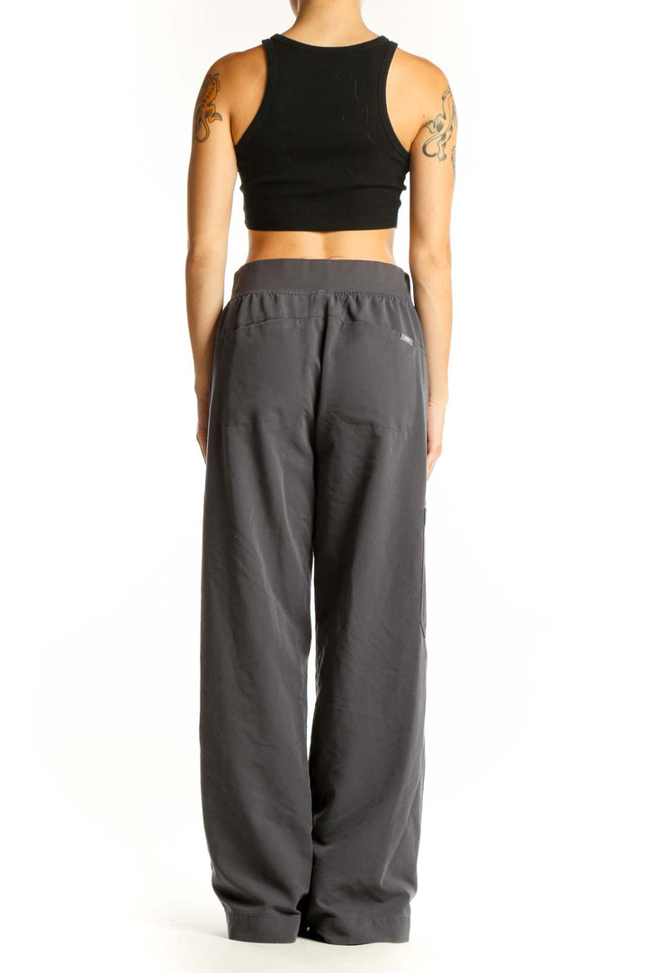 Side view of woman wearing FIGS gray cargo scrub pants with black top
