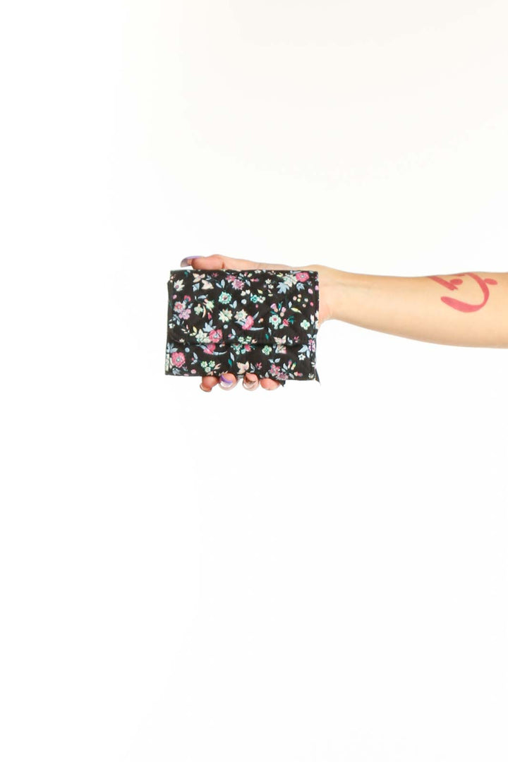 Black Floral Vera Bradley Clutch with pink and white flowers held in hand, showing quilted design and compact size