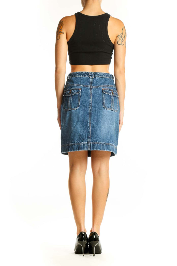 Side view of model wearing Ann Taylor LOFT blue denim A-line skirt with black crop top