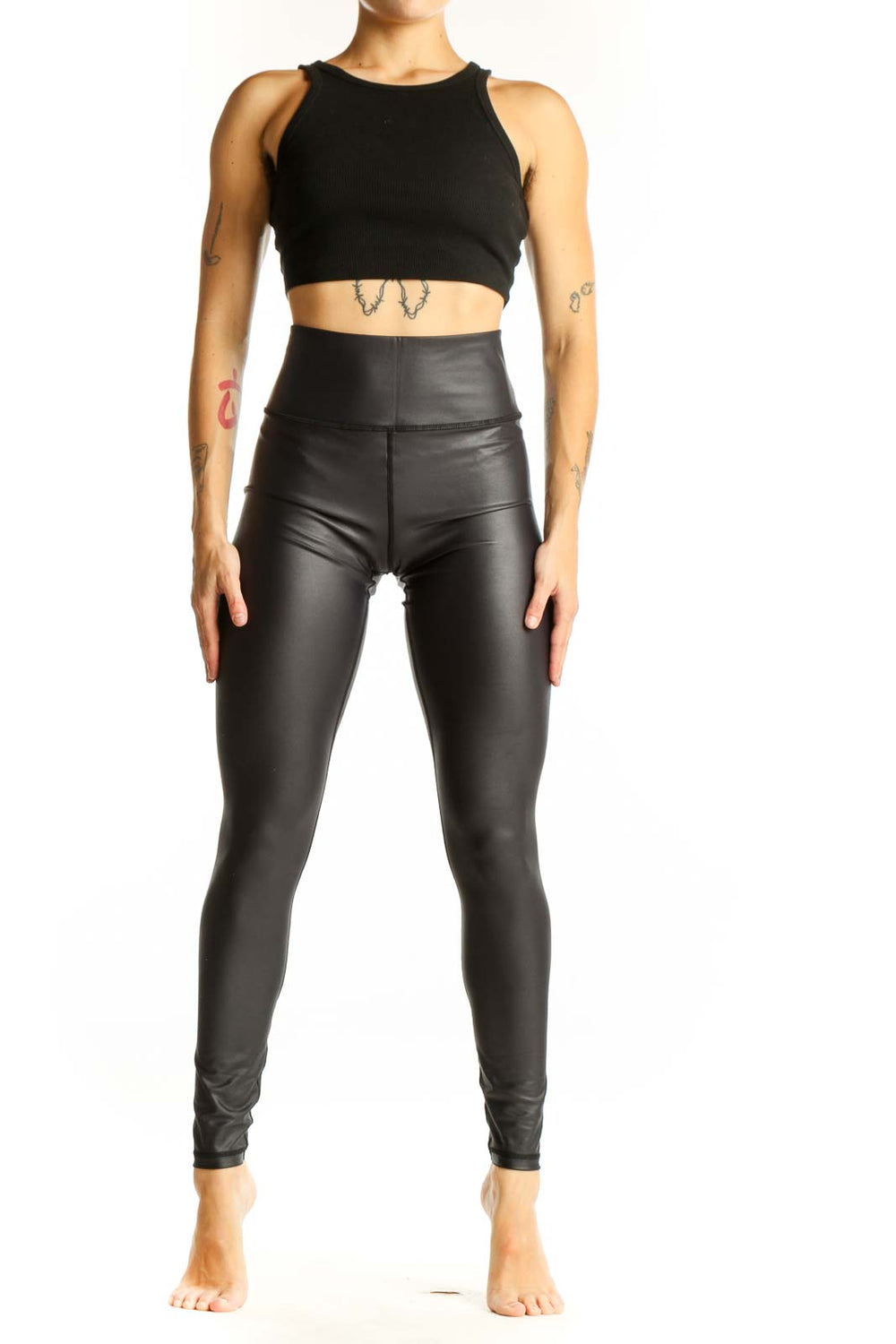 Front view of ZYIA black high-waisted faux leather leggings on model