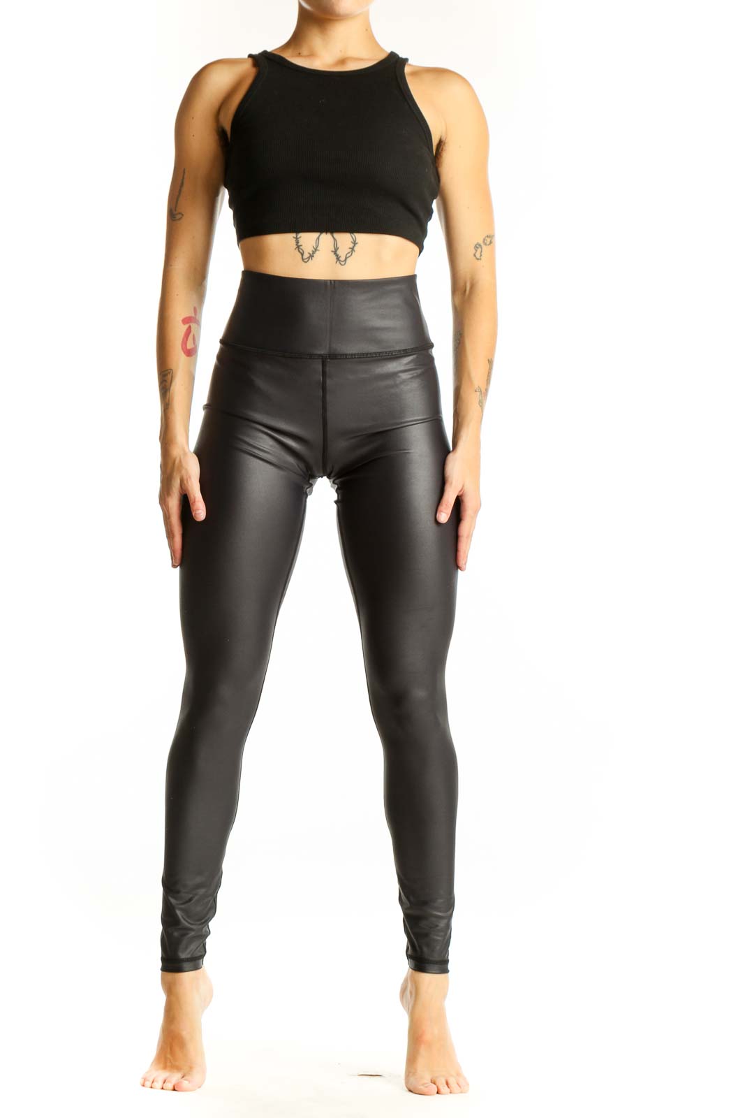 Front view of ZYIA black high-waisted faux leather leggings on model