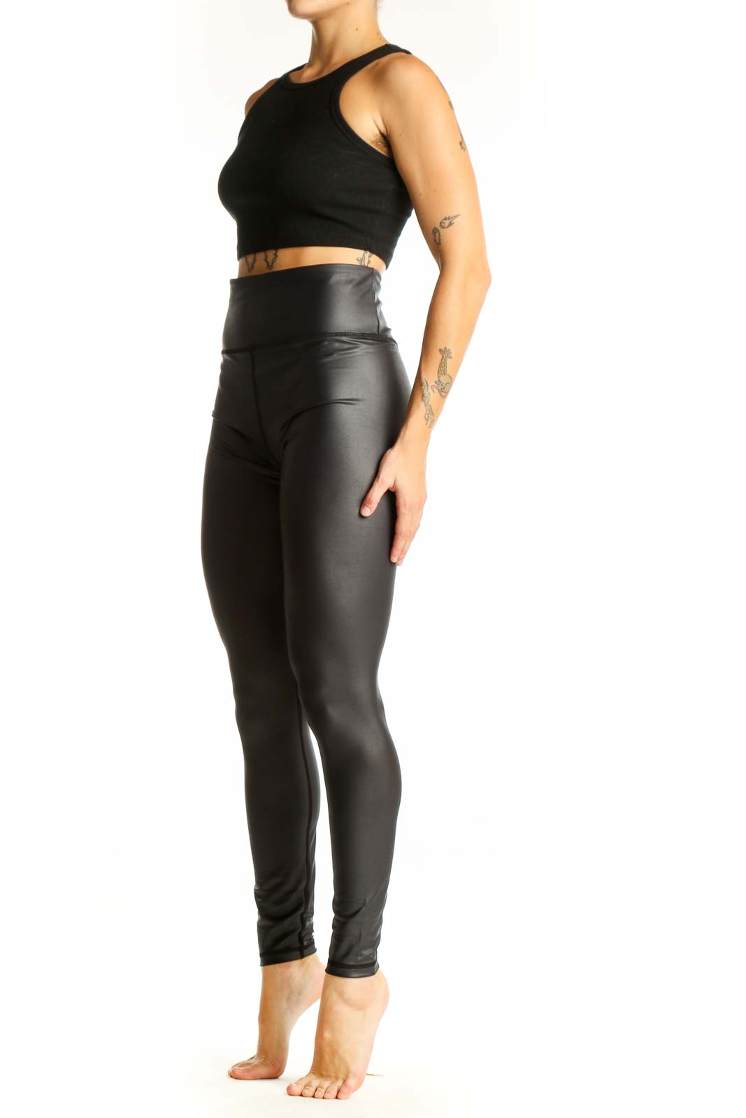 Front view of ZYIA black high-waisted faux leather leggings on model