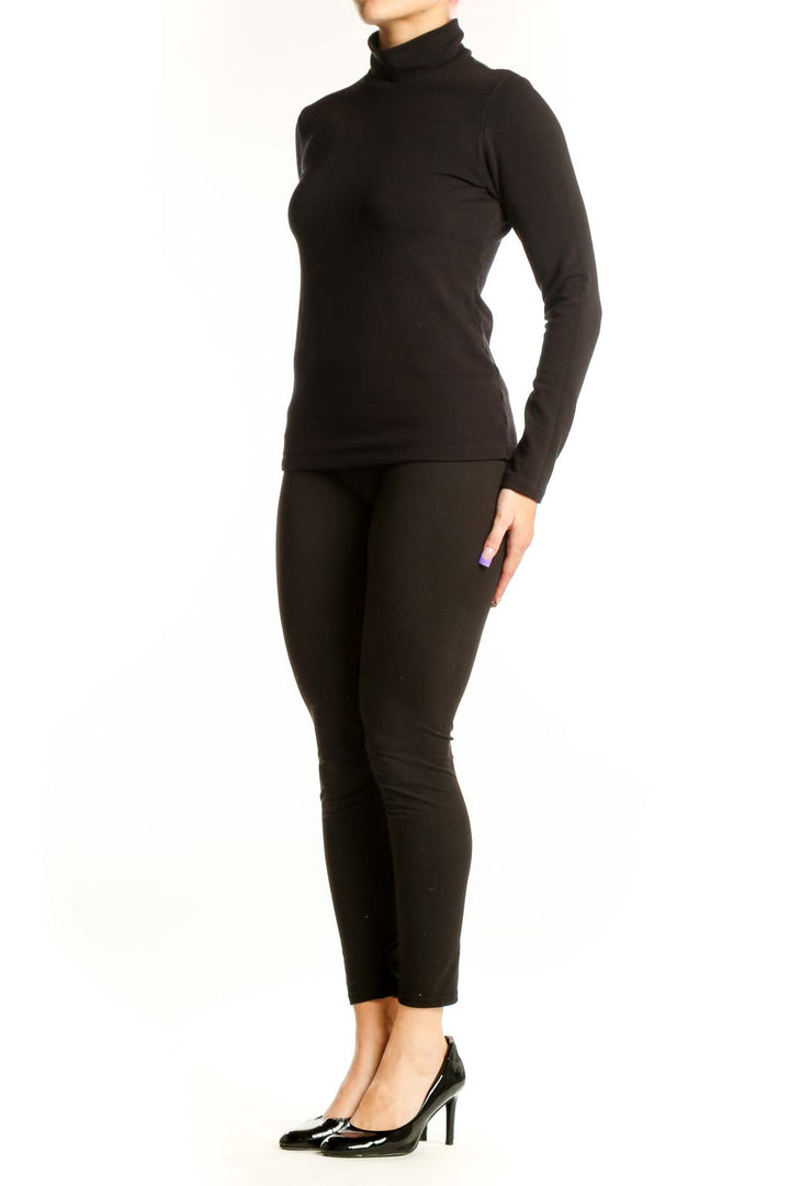Black turtleneck long sleeve fitted top by Uniqlo, front view on model