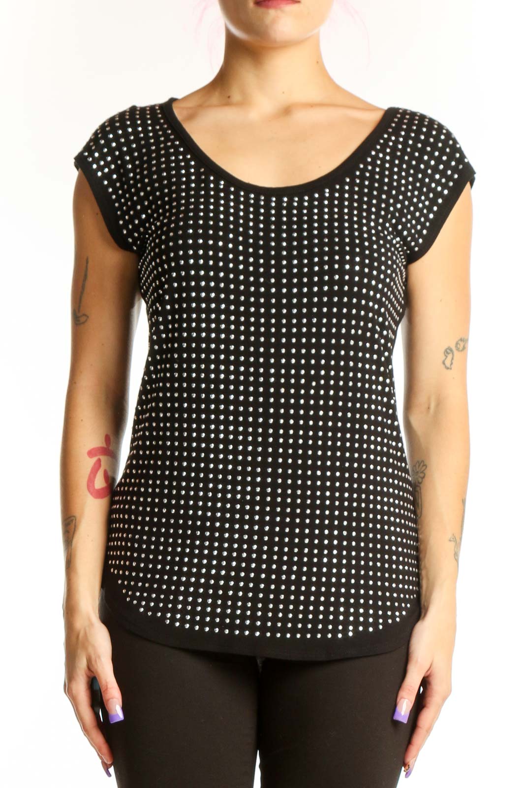 Black polka dot cap sleeve top with white dots, rounded neckline, and curved hem on model