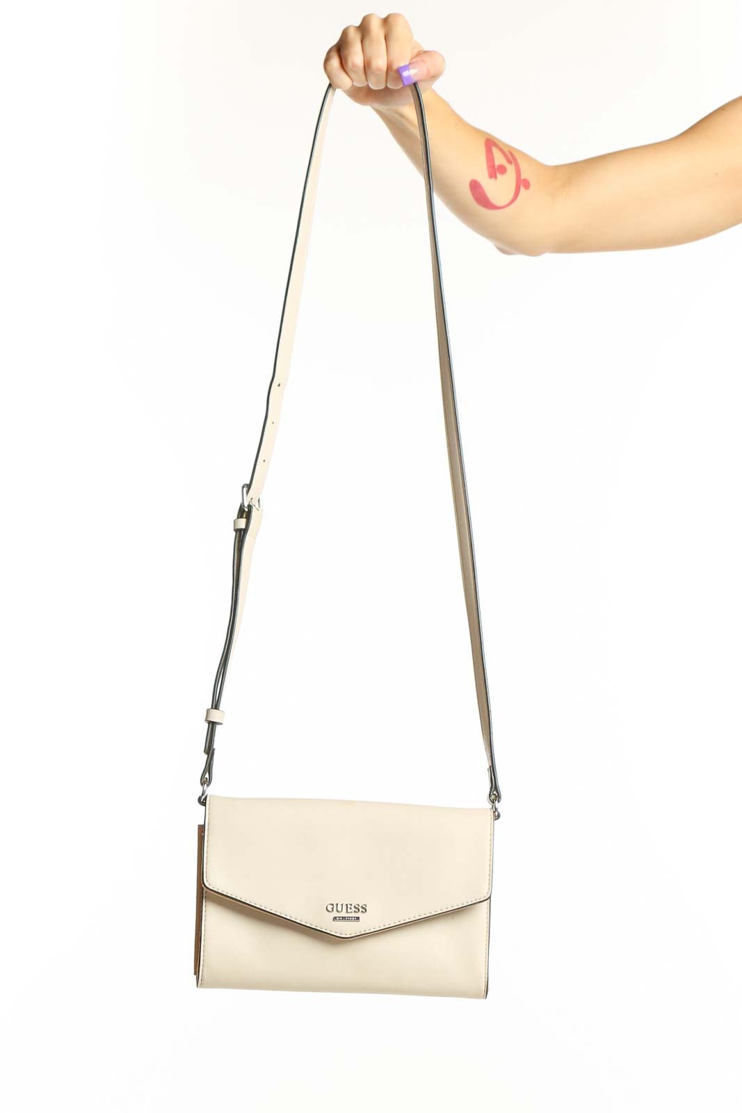 Cream Guess Crossbody Wallet Bag with adjustable strap and envelope flap design held in hand