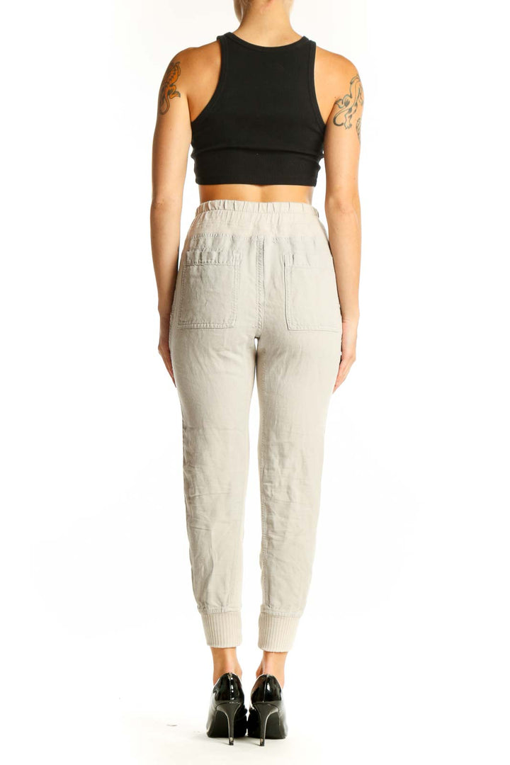 Side view of model wearing beige cotton jogger pants with black crop top