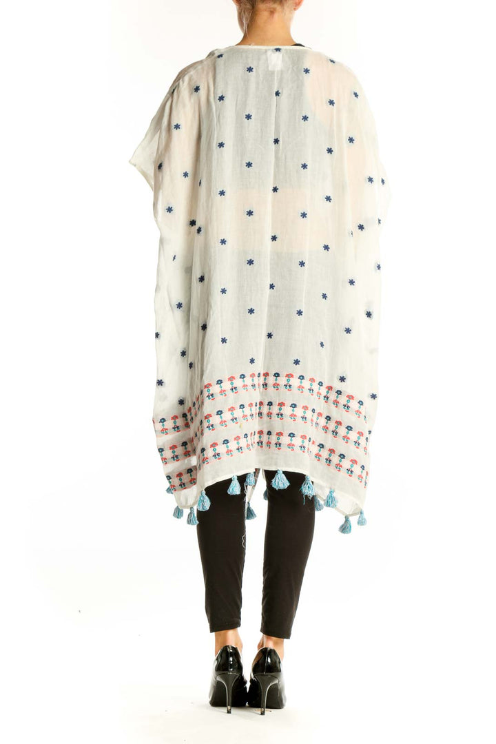Side view of white J.Crew kimono jacket showing floral print and tassel details