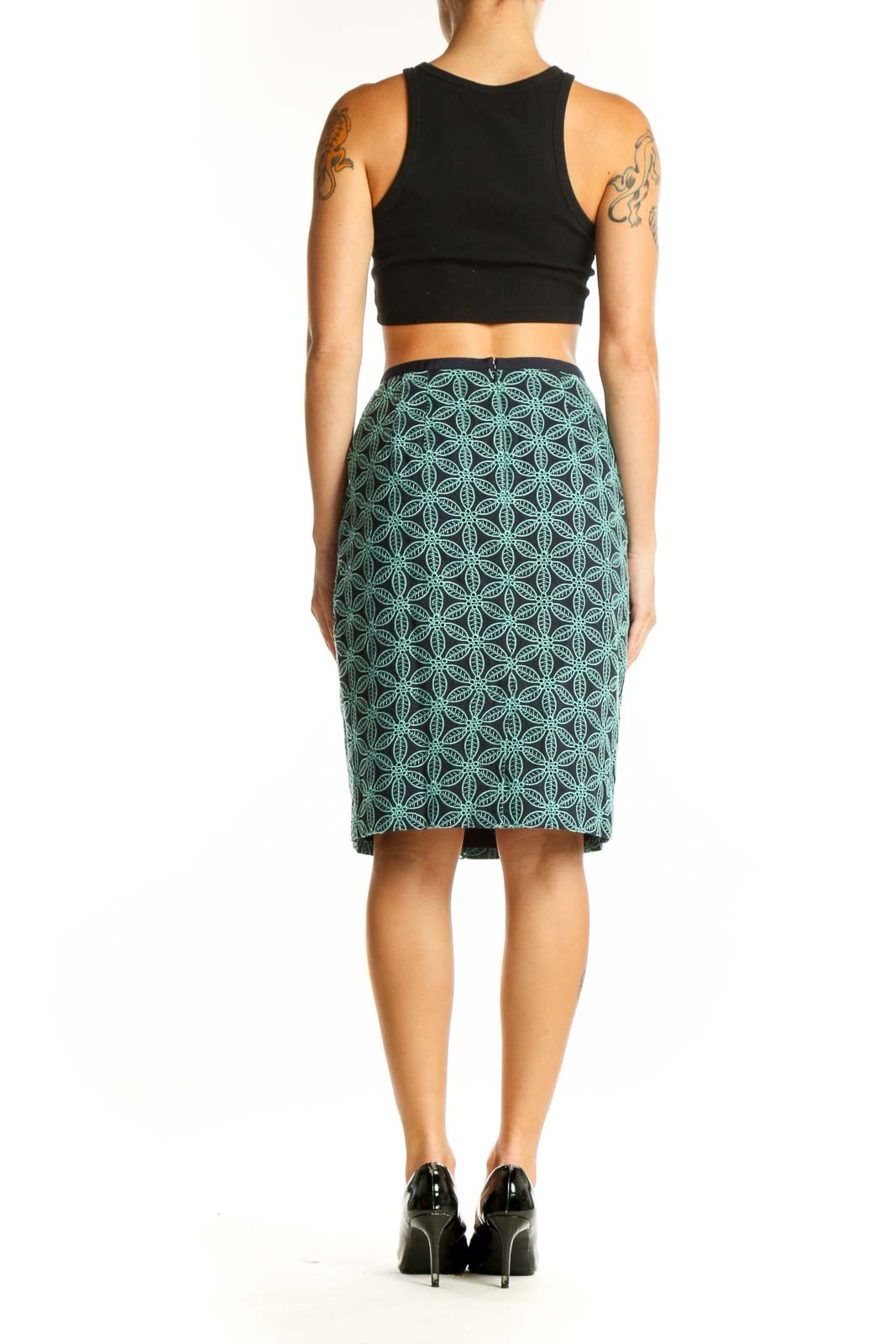 Side view of model wearing Talbots green geometric print pencil skirt with black top