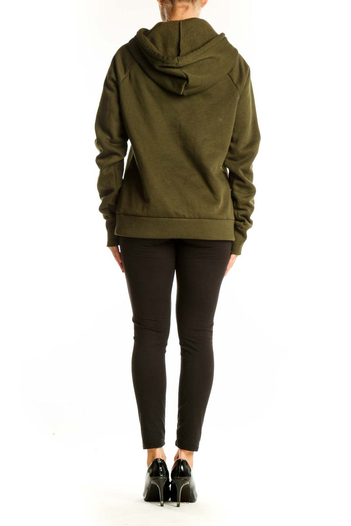 Side view of woman wearing olive Bebe Sport hoodie with black leggings