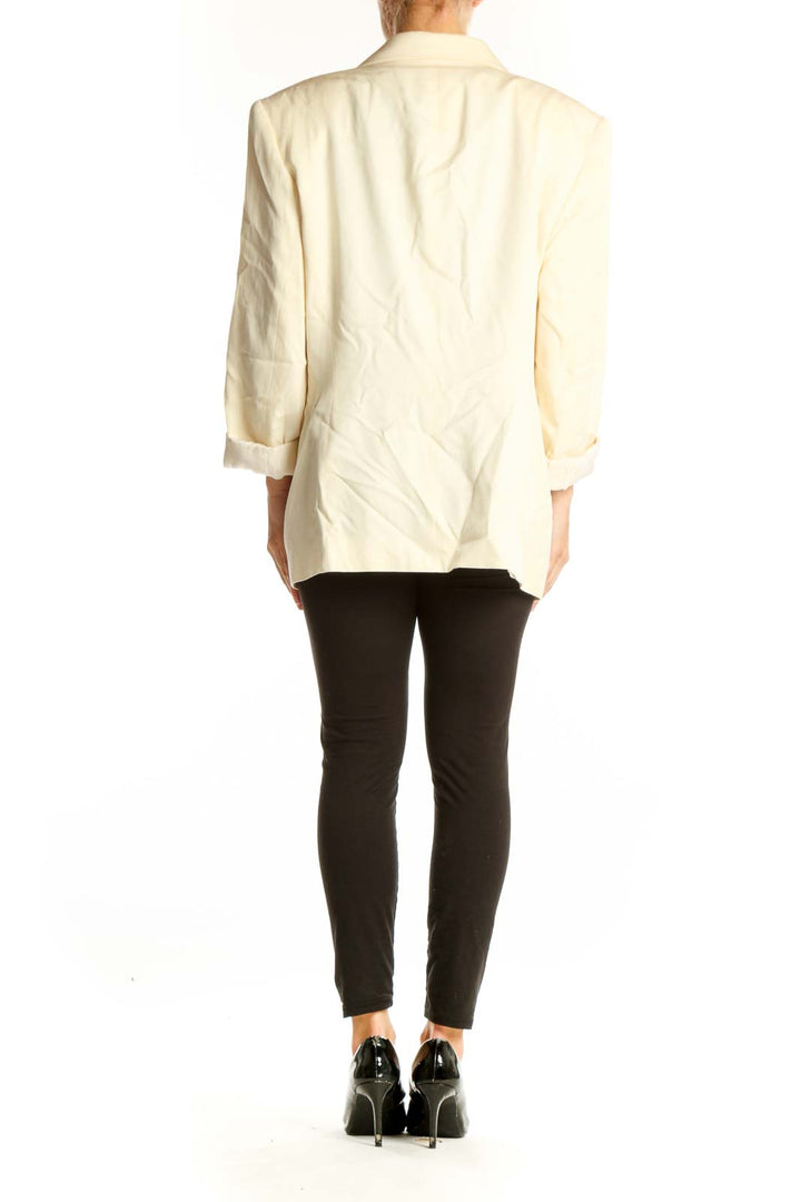 Side view of Ann Taylor cream oversized blazer on model with black outfit
