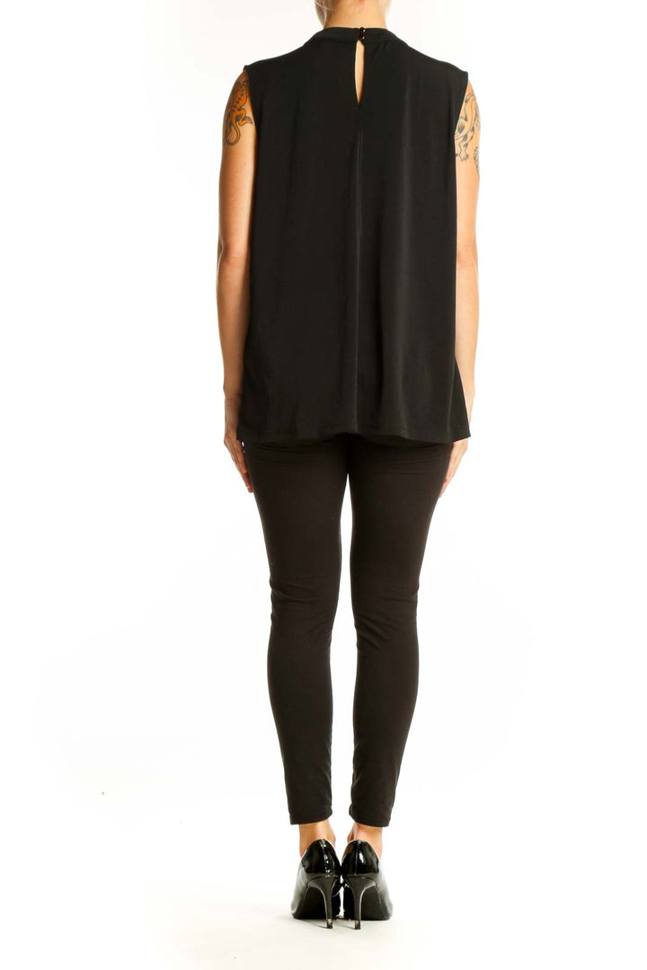 Side view of model wearing Banana Republic black sleeveless top with black pants