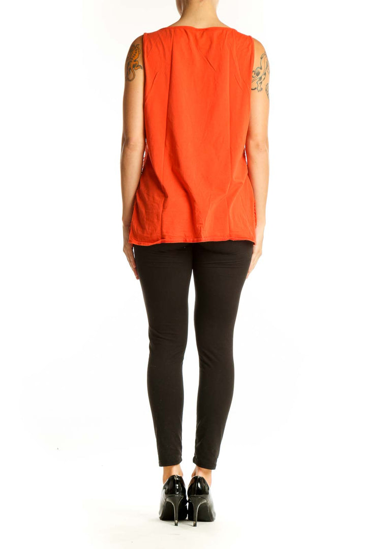 Side view of orange ribbed sleeveless top from Ann Taylor with black pants